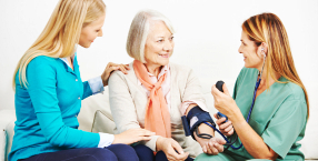 senior woman talking to her daughter and her caregiver